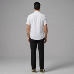 Man wearing black linen look stand collar shirt and tapered trousers in outdoor summer setting