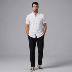 Man wearing black linen look stand collar shirt and slim tapered trousers walking in outdoor lifestyle