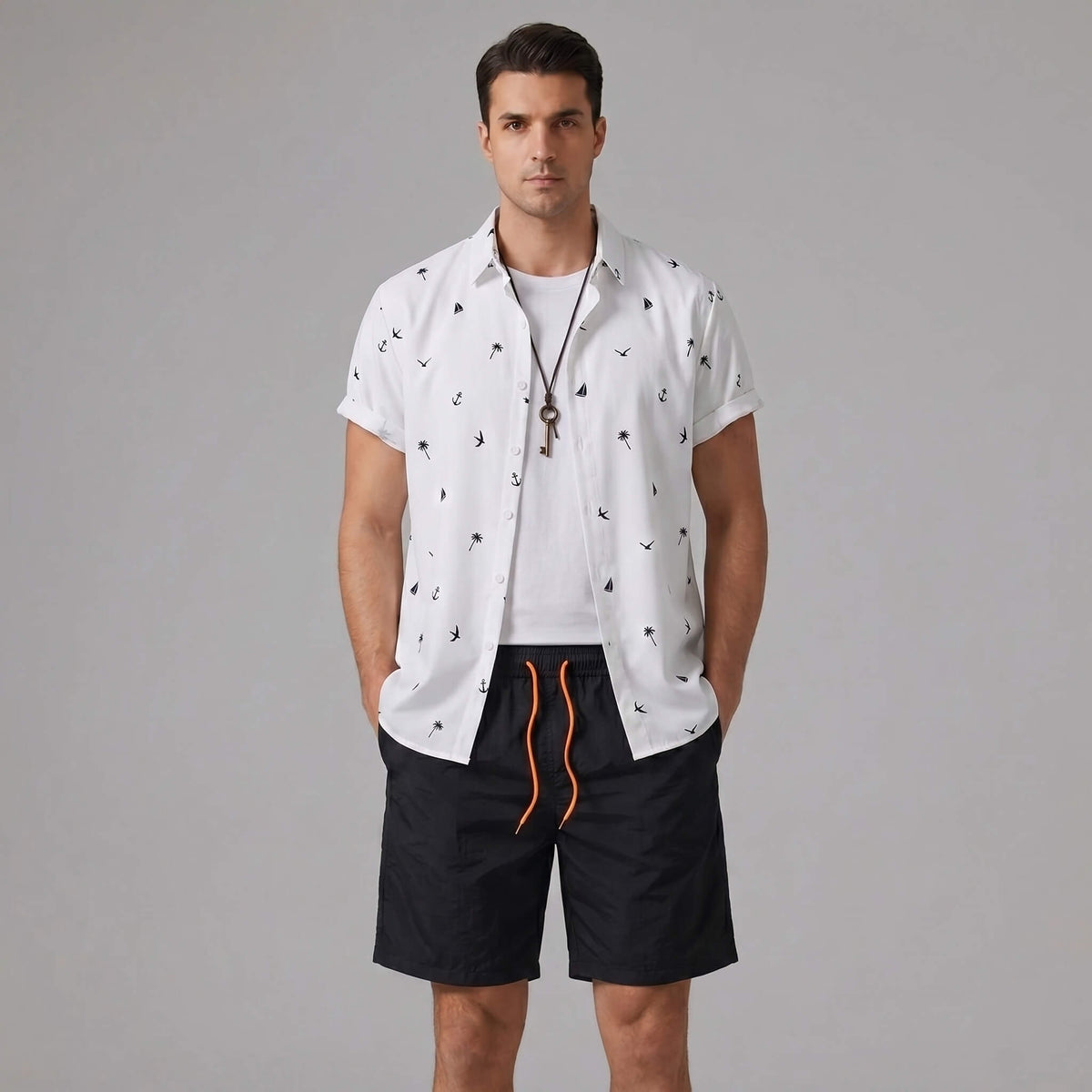 Man wearing a black palm tree anchor sailboat print button up shirt and swim shorts front view
