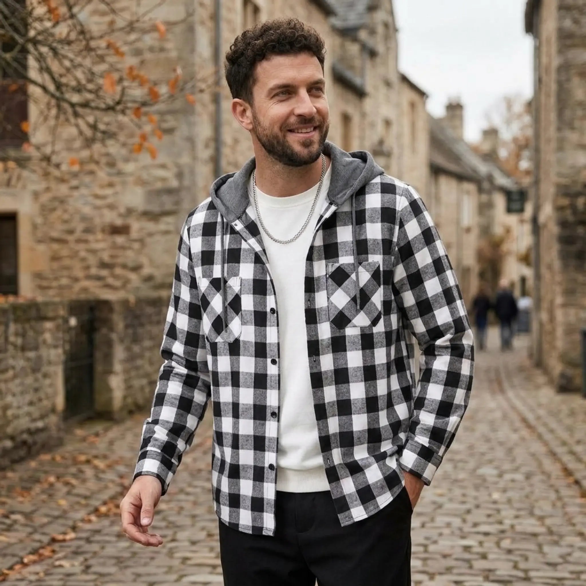 MannerCo black plaid hooded shirt jacket worn open over white tee on cobblestone street