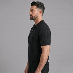 Man wearing a black stripe jacquard knit zip-up polo shirt front view on plain background
