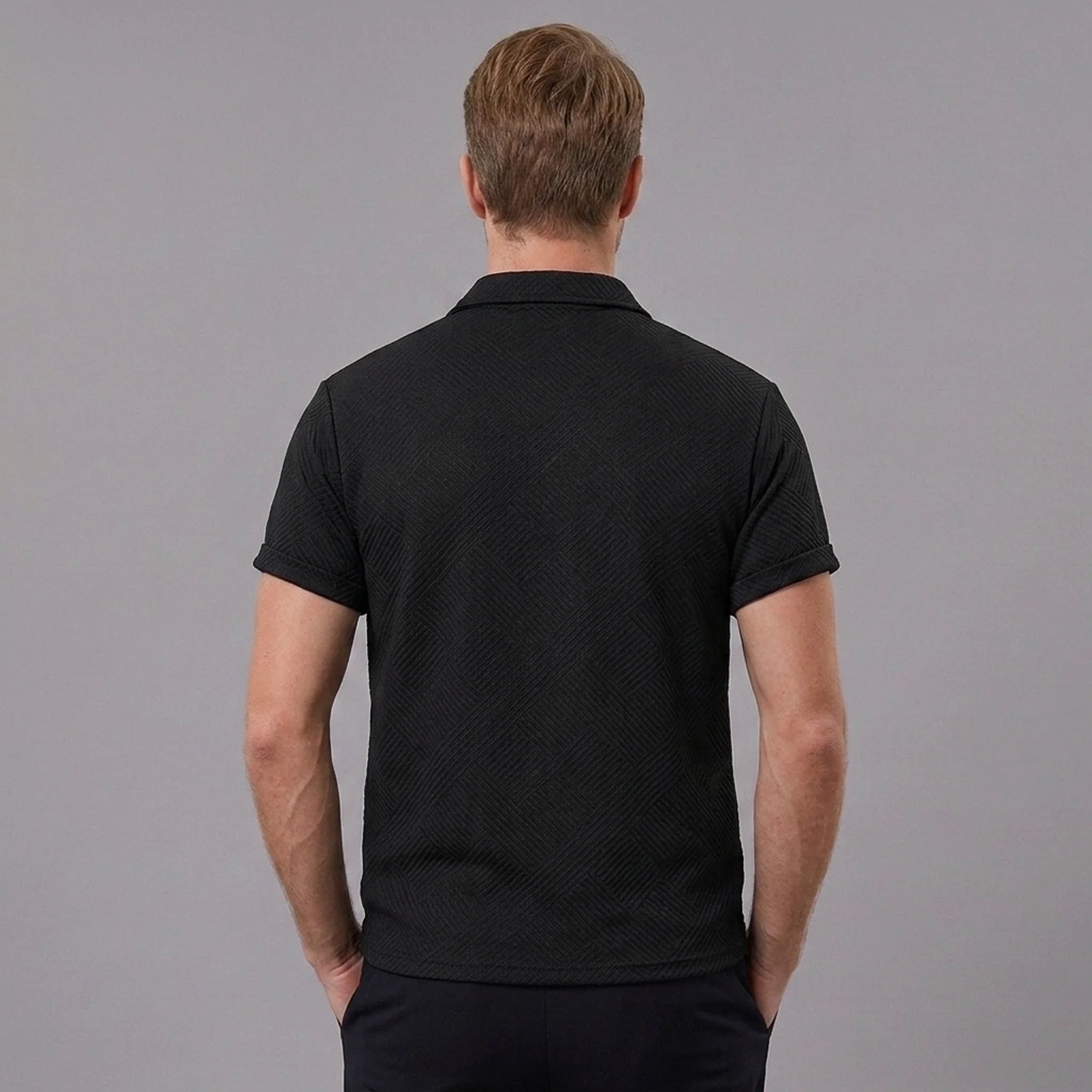 Back view of man wearing black stripe jacquard zip-up polo shirt