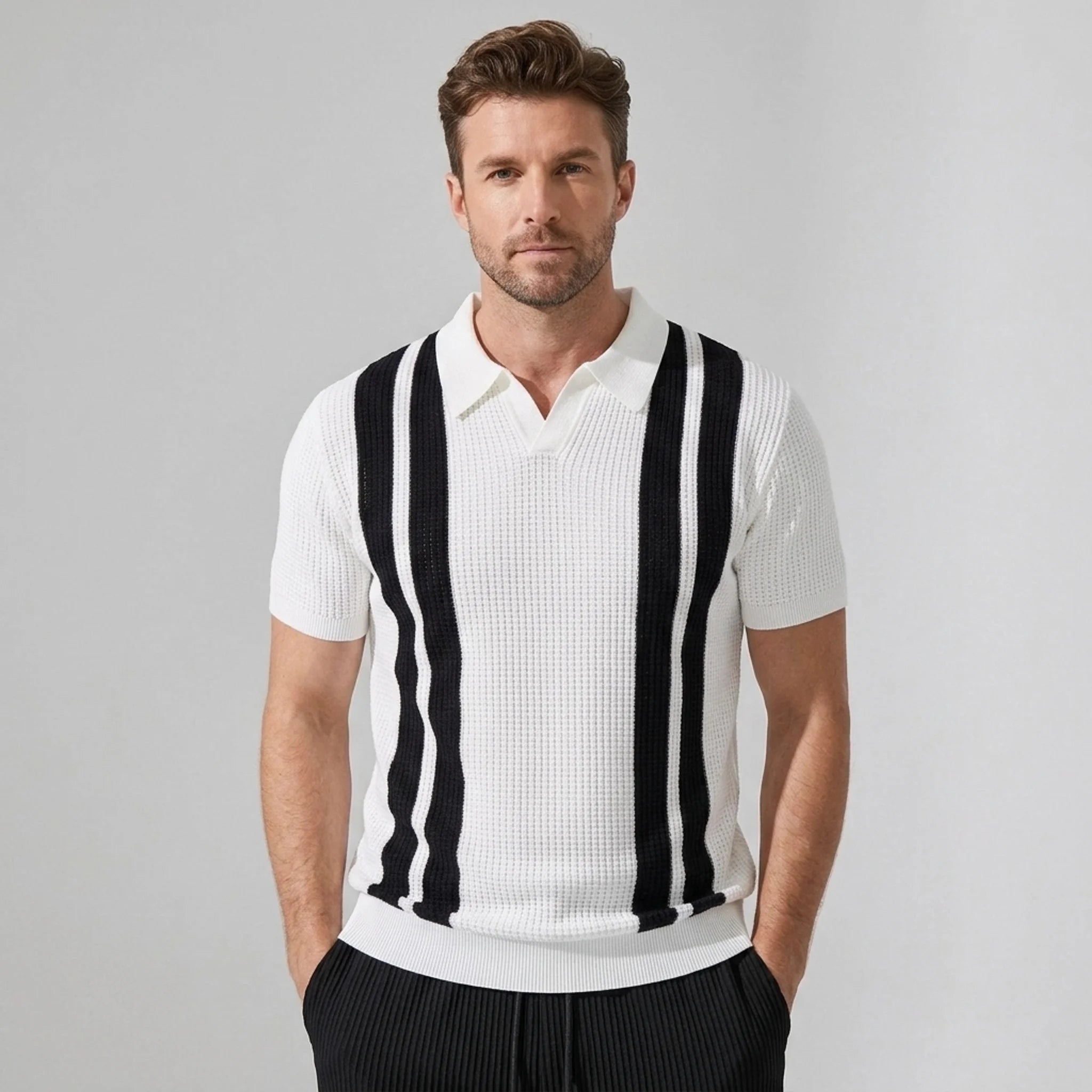Man wearing a white polo shirt with black vertical stripes on a gray background