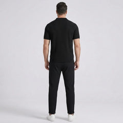 Three quarter view of man in black striped knit polo and waffle drawstring pants outdoors