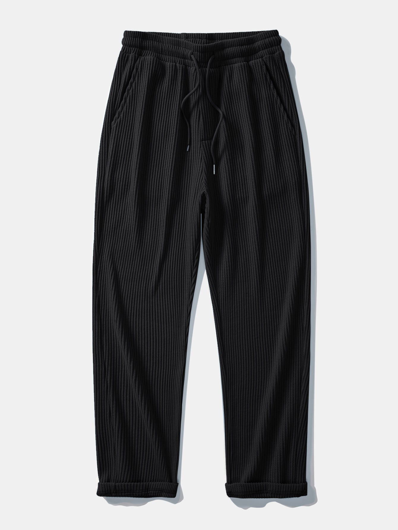 Man in black striped knit polo and waffle pants outdoor setting