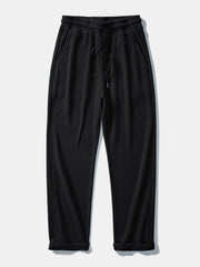 Man in black striped knit polo and waffle pants outdoor setting