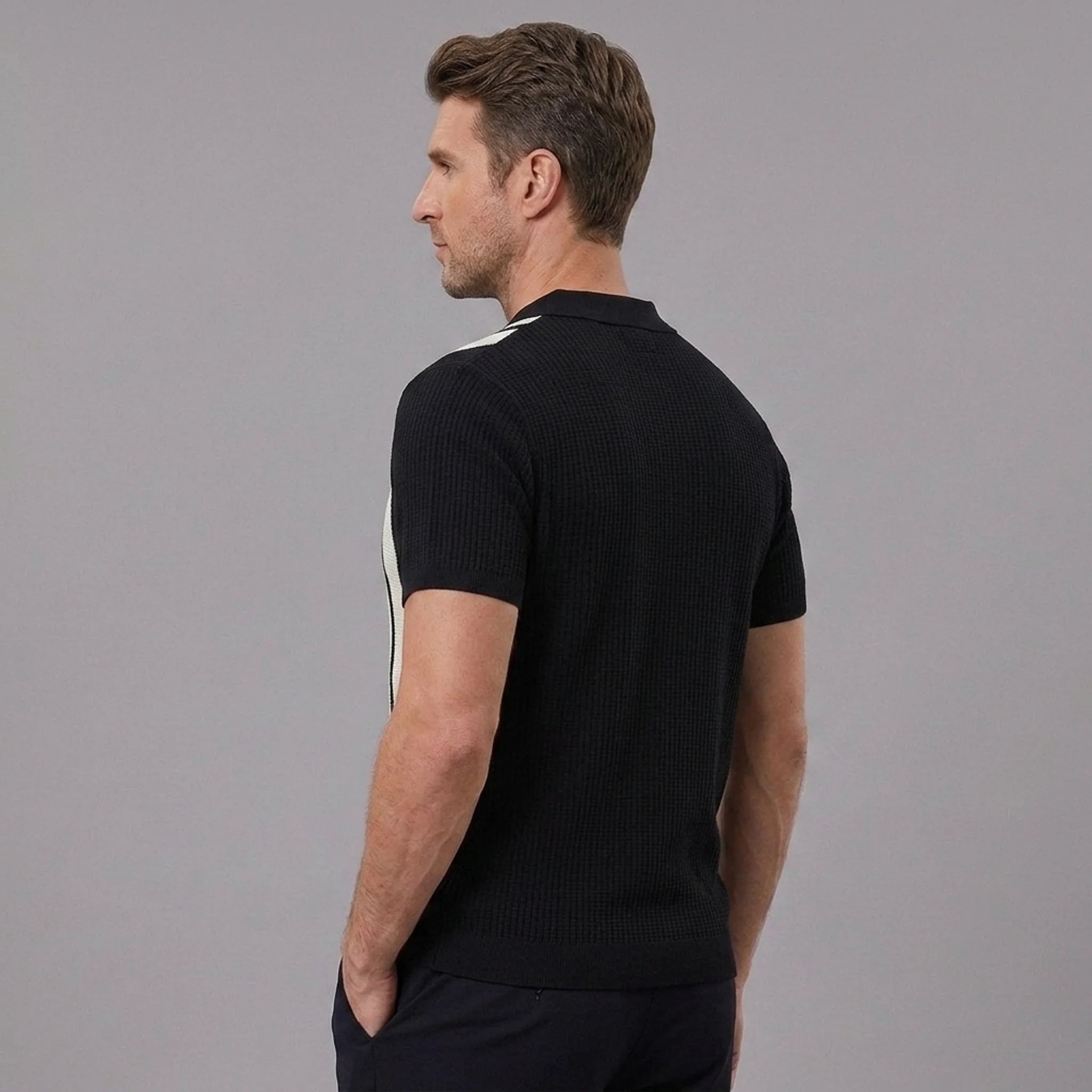 Back view of man wearing black striped knit slim fit polo shirt