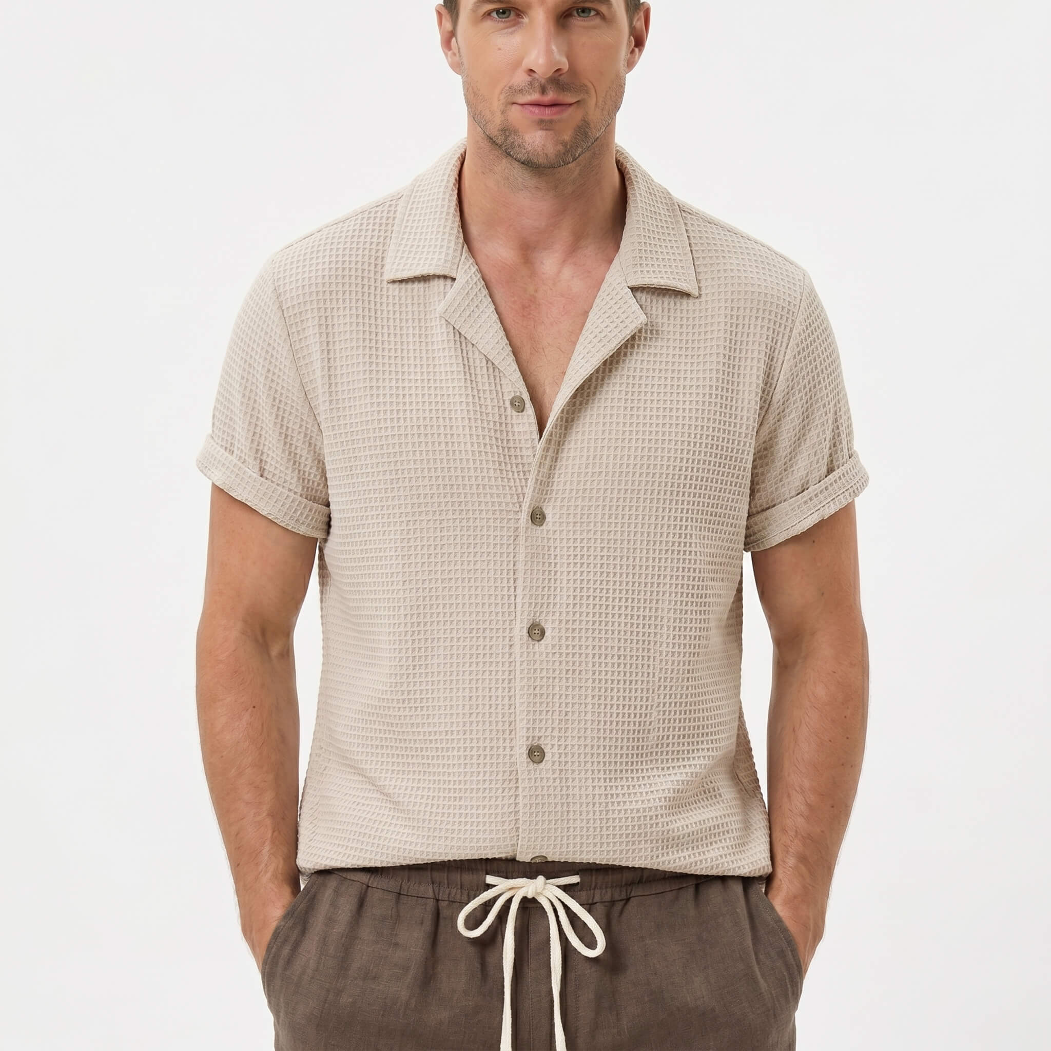 Man wearing black textured Cuban shirt and linen cotton drawstring shorts front view on plain background