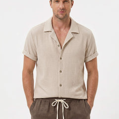 Man wearing black textured Cuban shirt and linen cotton drawstring shorts front view on plain background