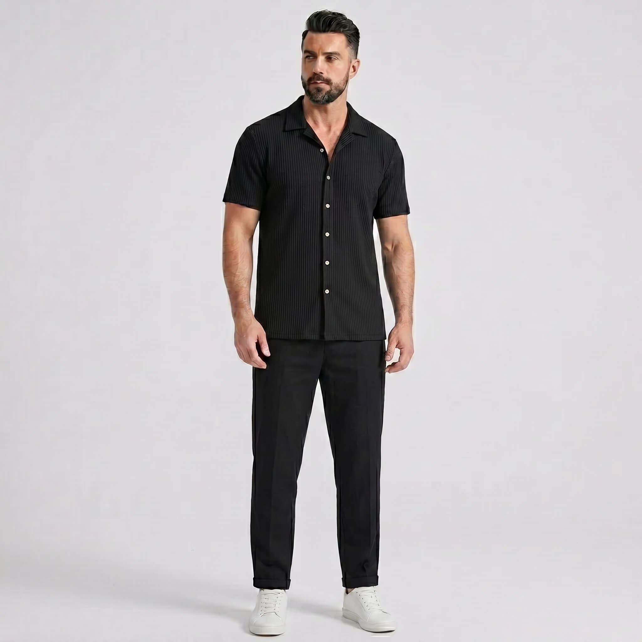 Man wearing a black waffle button up shirt and straight leg linen pants front view