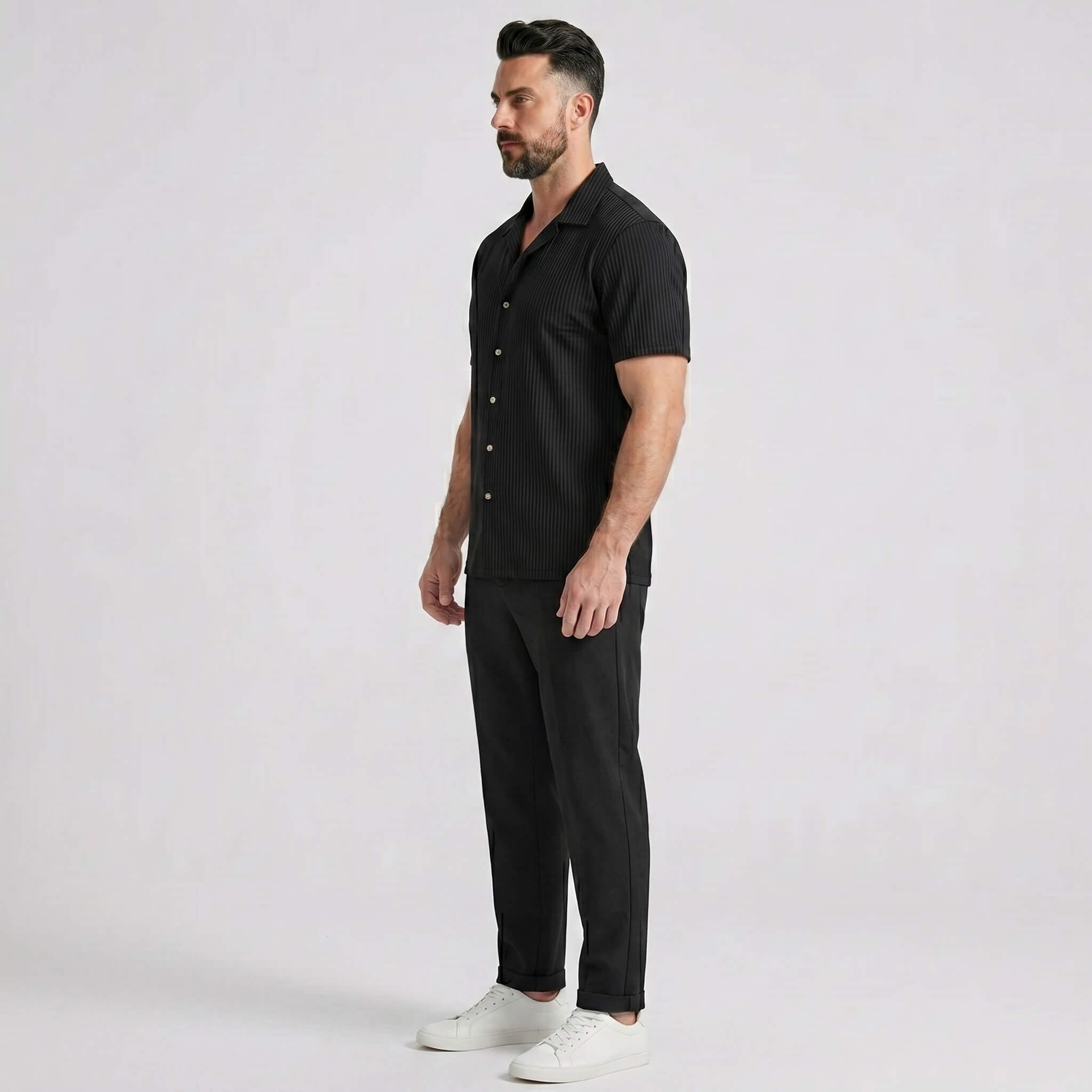 Side view of man in black waffle button up shirt and straight leg linen pants