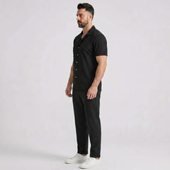 Side view of man in black waffle button up shirt and straight leg linen pants