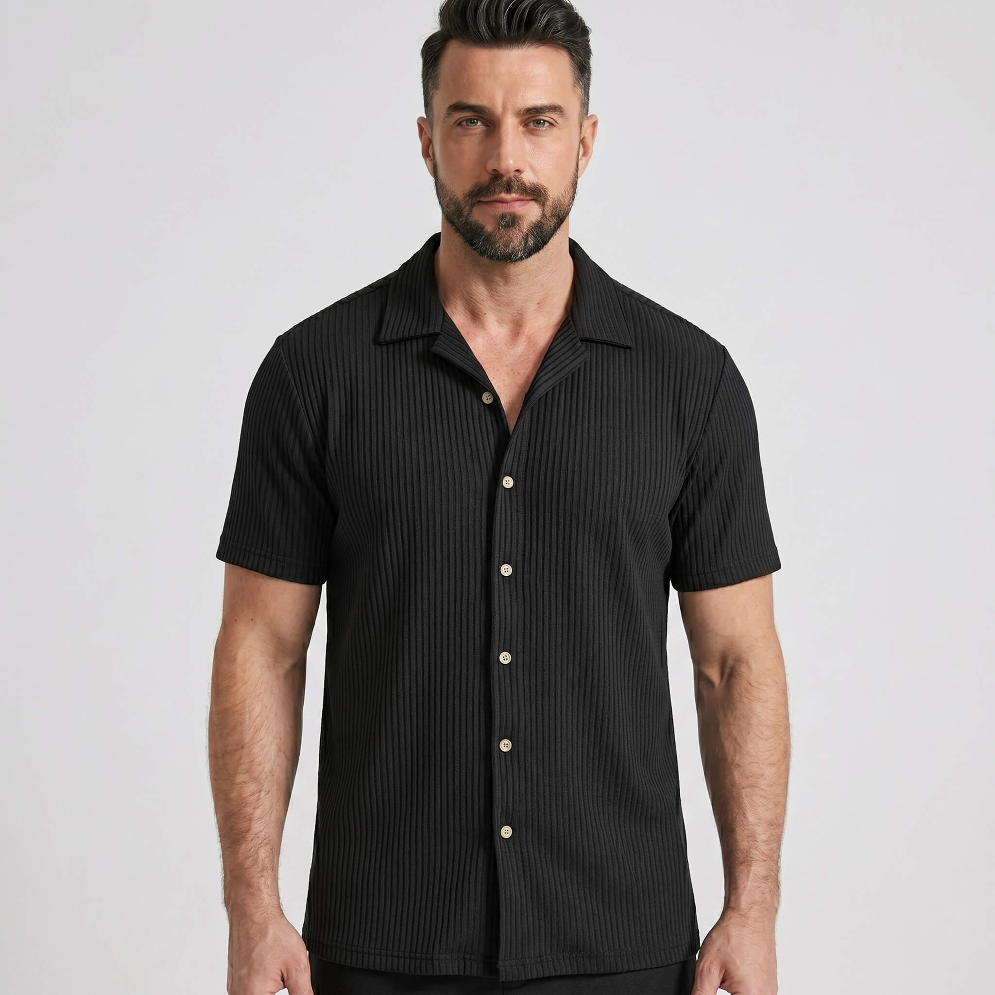 Three quarter view of man in black waffle button up shirt and straight leg linen pants