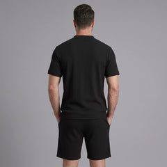 Back view of man wearing black waffle stand collar shirt and drawstring shorts