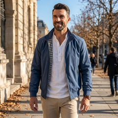 Man wearing MannerCo blue solid bomber jacket in outdoor lifestyle setting