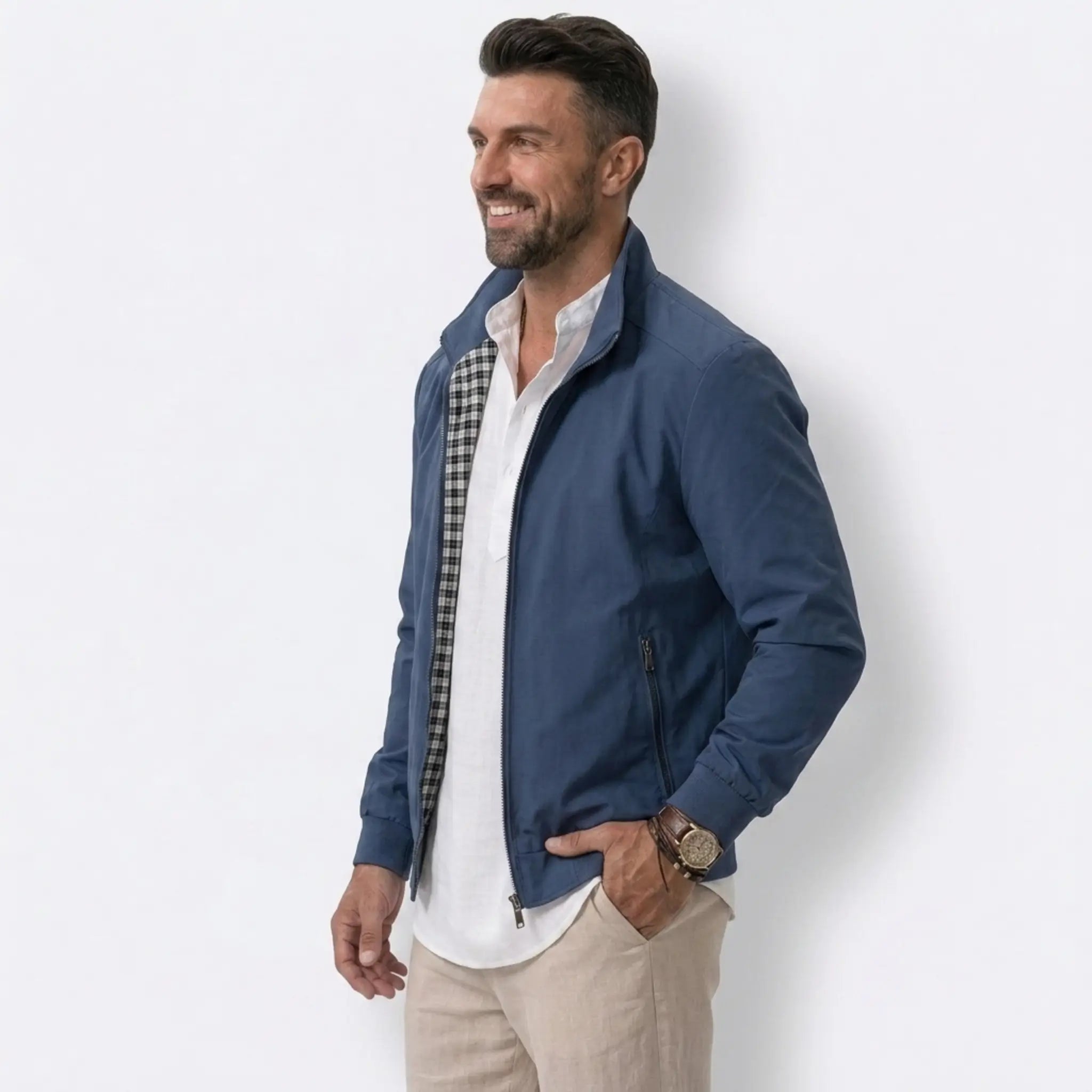 Man wearing MannerCo blue solid bomber jacket with stand collar, side view on plain background