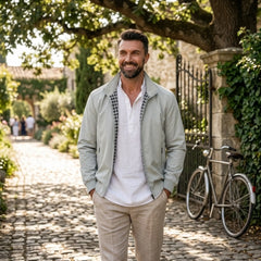Man wearing MannerCo gray solid bomber jacket in outdoor lifestyle setting