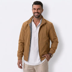 Man wearing MannerCo khaki solid bomber jacket with stand collar and zip closure, front view