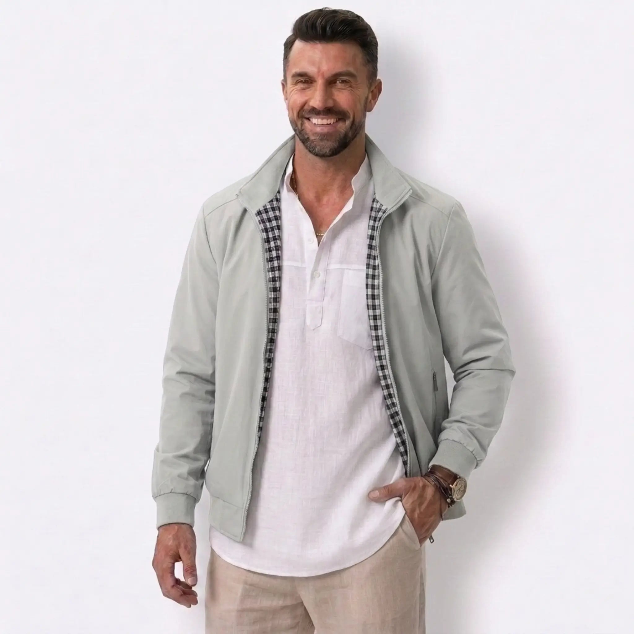 Man wearing MannerCo khaki solid bomber jacket in outdoor lifestyle setting