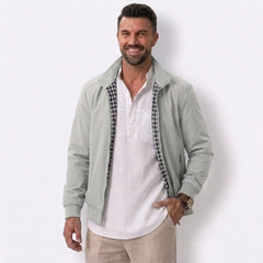 Man wearing MannerCo khaki solid bomber jacket in outdoor lifestyle setting