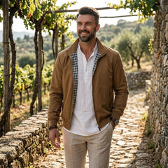 Man wearing MannerCo khaki solid bomber jacket in outdoor lifestyle setting