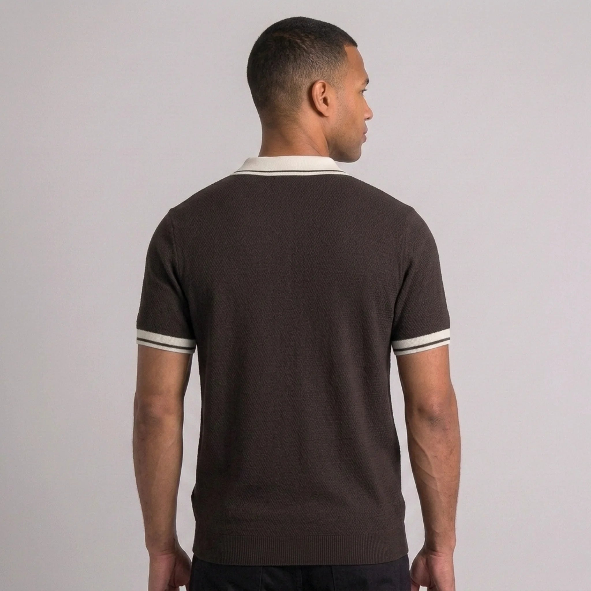 Back view of man wearing brown color block knit polo shirt with lapel collar