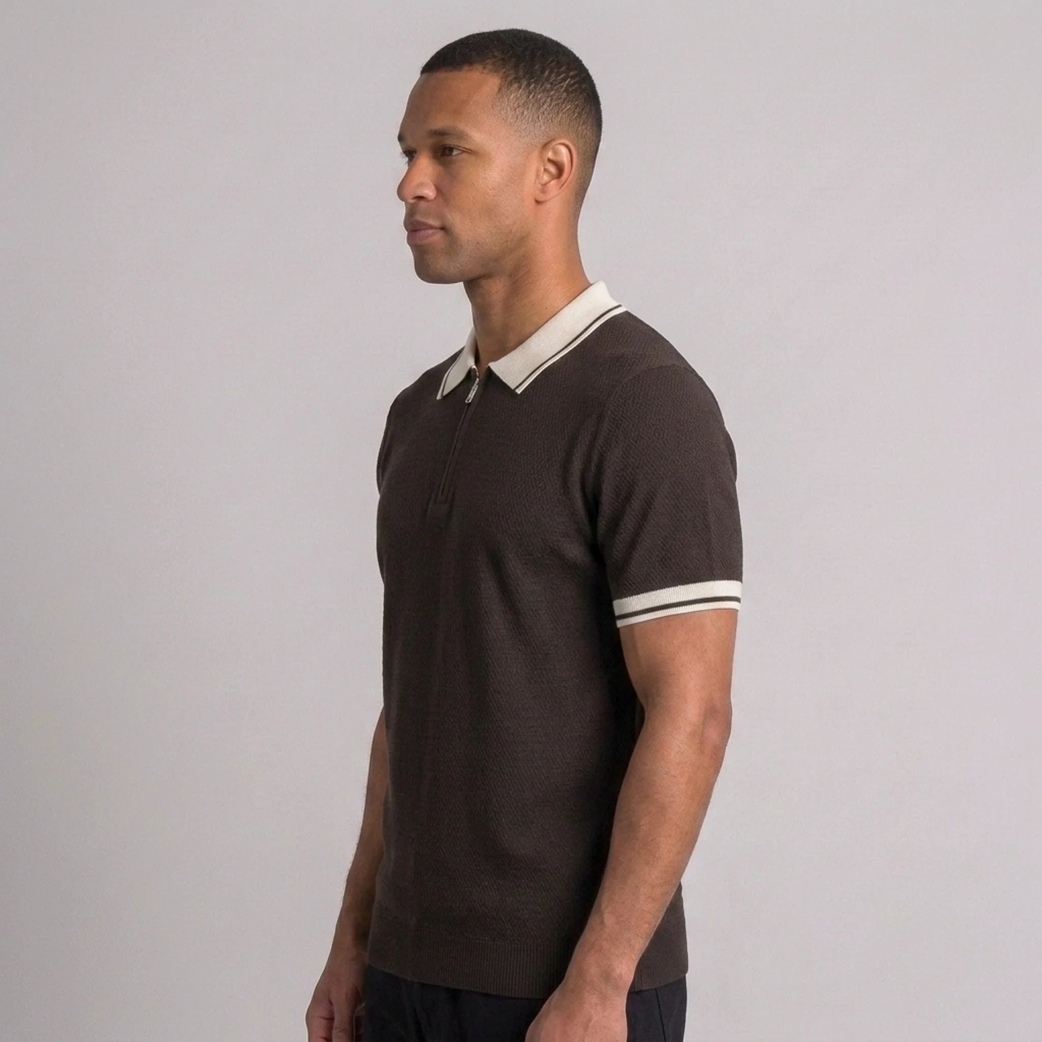Side view of man in brown color block knit polo shirt with lapel collar