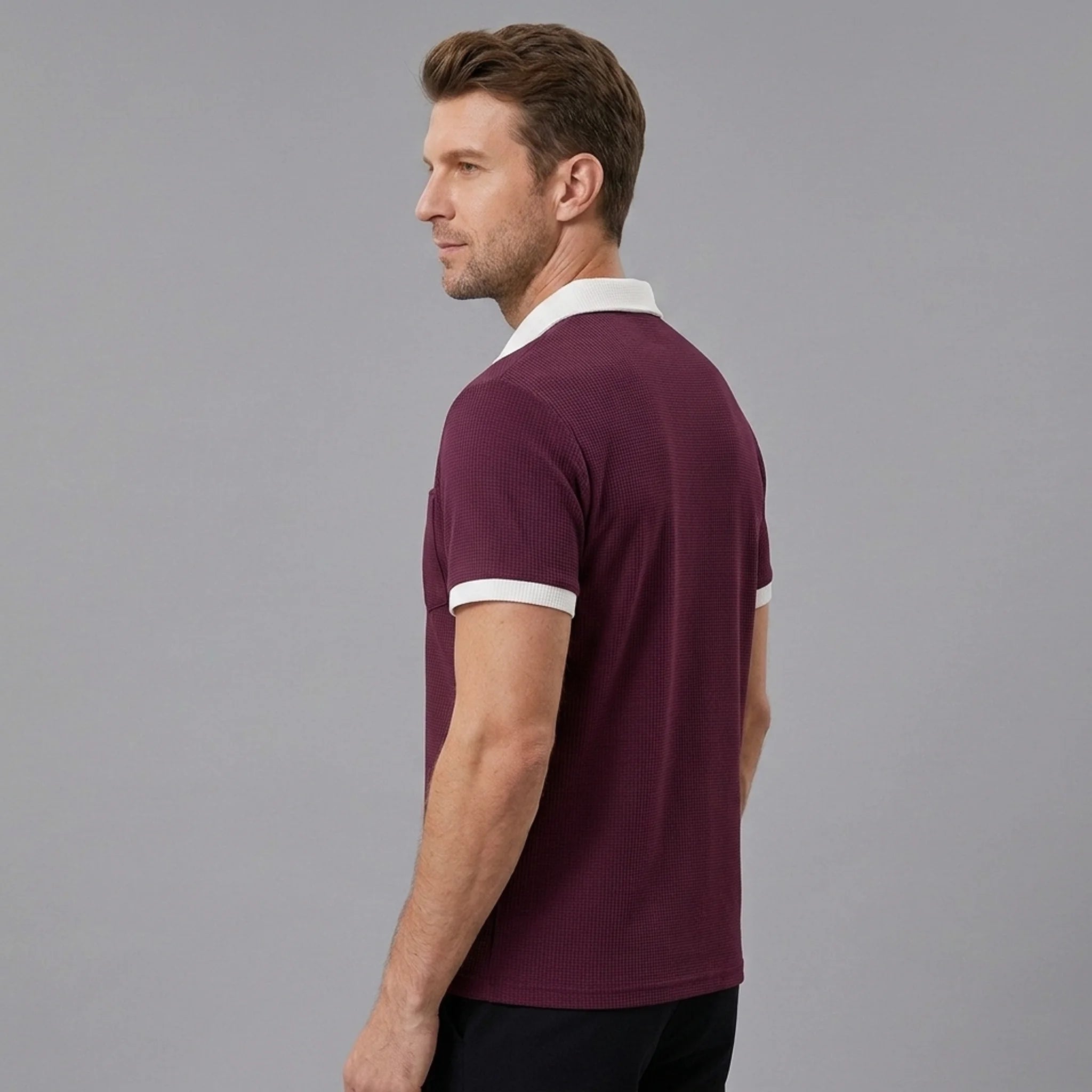 Man wearing burgundy color block waffle polo shirt in outdoor lifestyle setting