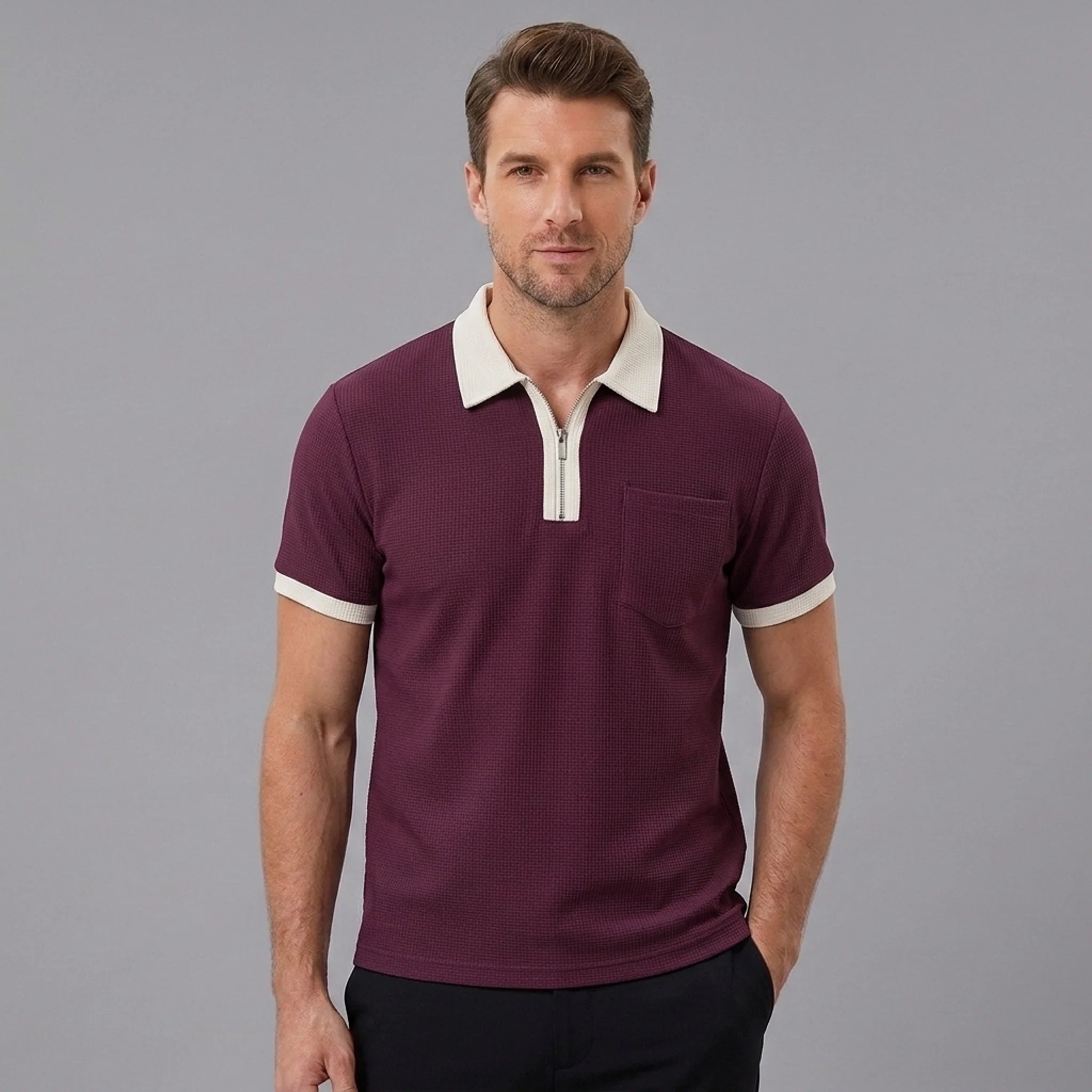 Side view of man in burgundy color block waffle polo shirt on plain background