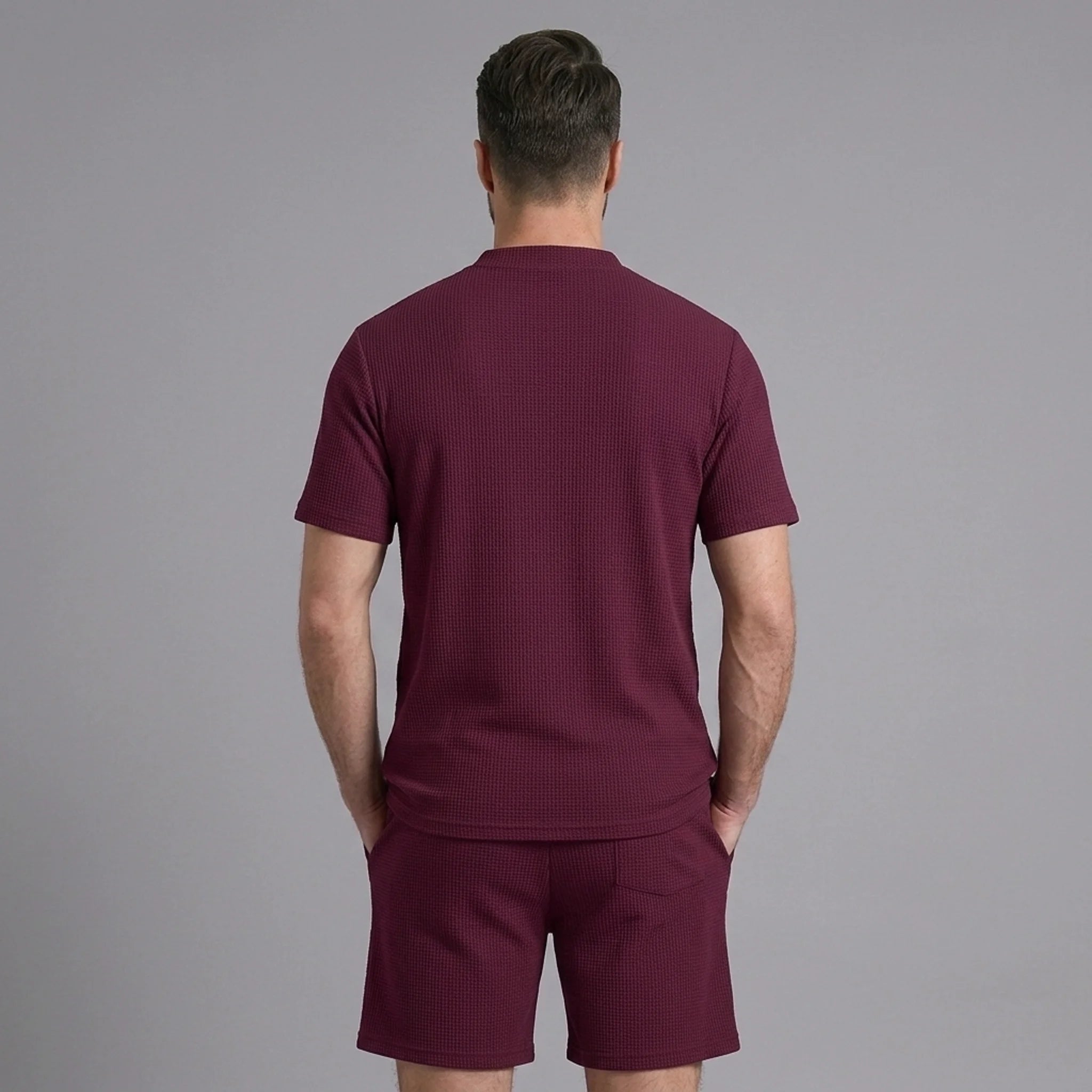 Back view of man wearing claret waffle stand collar shirt and drawstring shorts