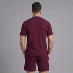 Back view of man wearing claret waffle stand collar shirt and drawstring shorts