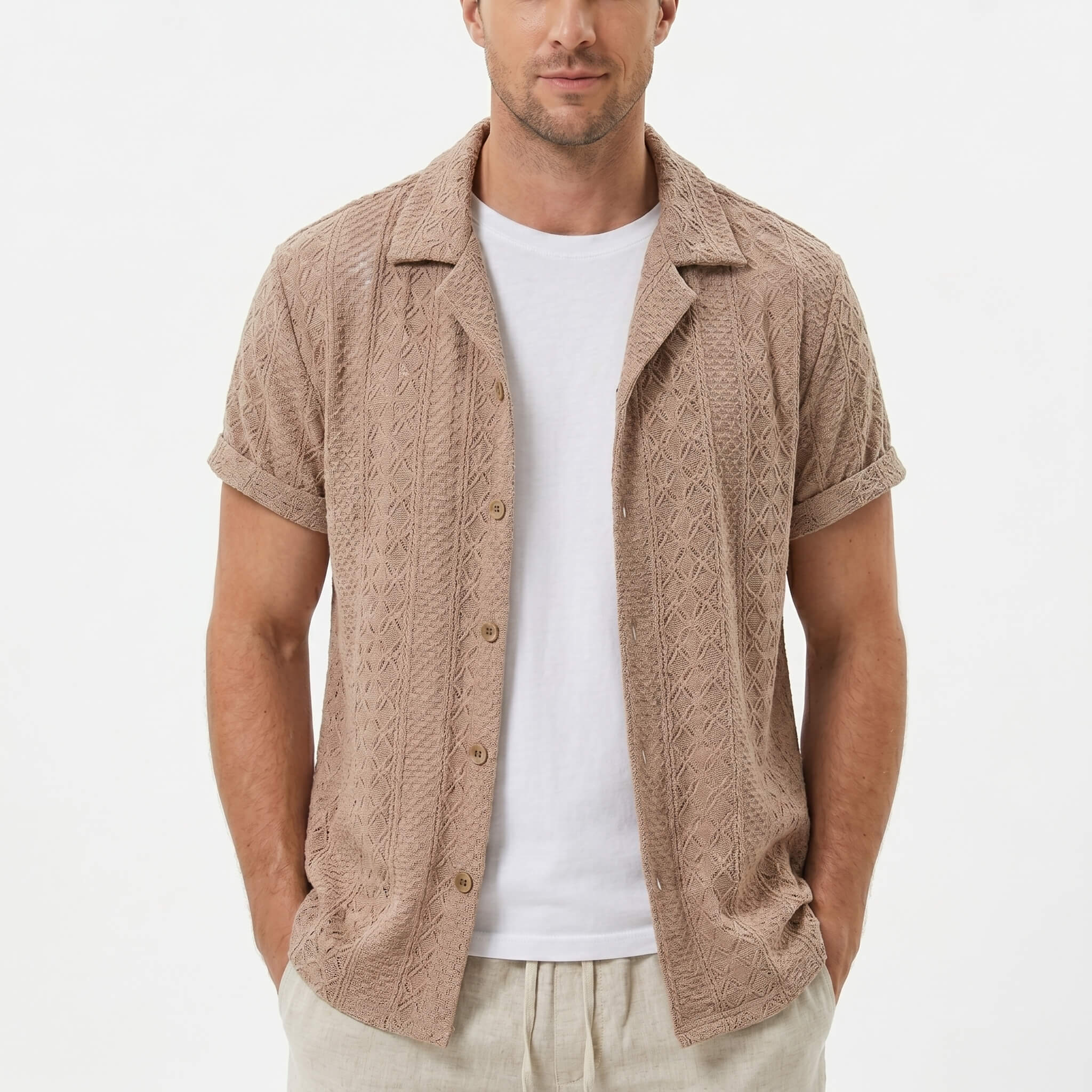 Three quarter view of man in coffee brown floral checkerboard jacquard Cuban shirt and drawstring shorts