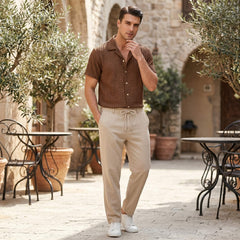 Man wearing coffee brown jacquard Cuban collar shirt and crinkle pants in outdoor lifestyle setting