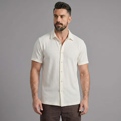 Three quarter view of man in coffee brown waffle button up shirt and linen pants
