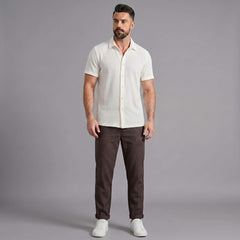 Man wearing a coffee brown waffle button up shirt and straight leg linen pants front view
