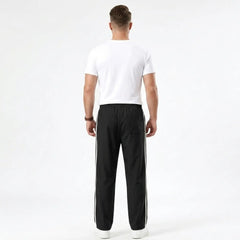 Man wearing MannerCo black color-block drawstring jogger pants in outdoor lifestyle setting