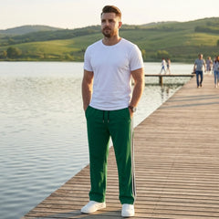 Man wearing MannerCo grass green color-block drawstring jogger pants in outdoor lifestyle setting