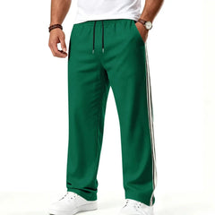 Man wearing MannerCo grass green color-block drawstring jogger pants, side view on plain background
