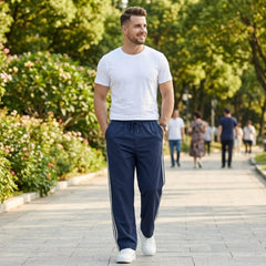 Man wearing MannerCo navy blue color-block jogger pants in outdoor lifestyle setting