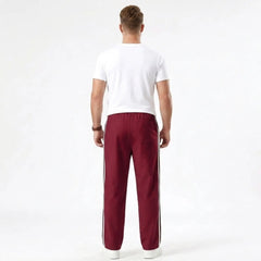 Man wearing MannerCo wine red color-block drawstring jogger pants in outdoor lifestyle setting