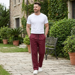 Man wearing MannerCo wine red color-block drawstring jogger pants in outdoor lifestyle setting