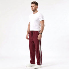 Man wearing MannerCo wine red color-block drawstring jogger pants in outdoor lifestyle setting