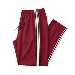 Man wearing MannerCo wine red color-block drawstring jogger pants with contrast tape detail, side view