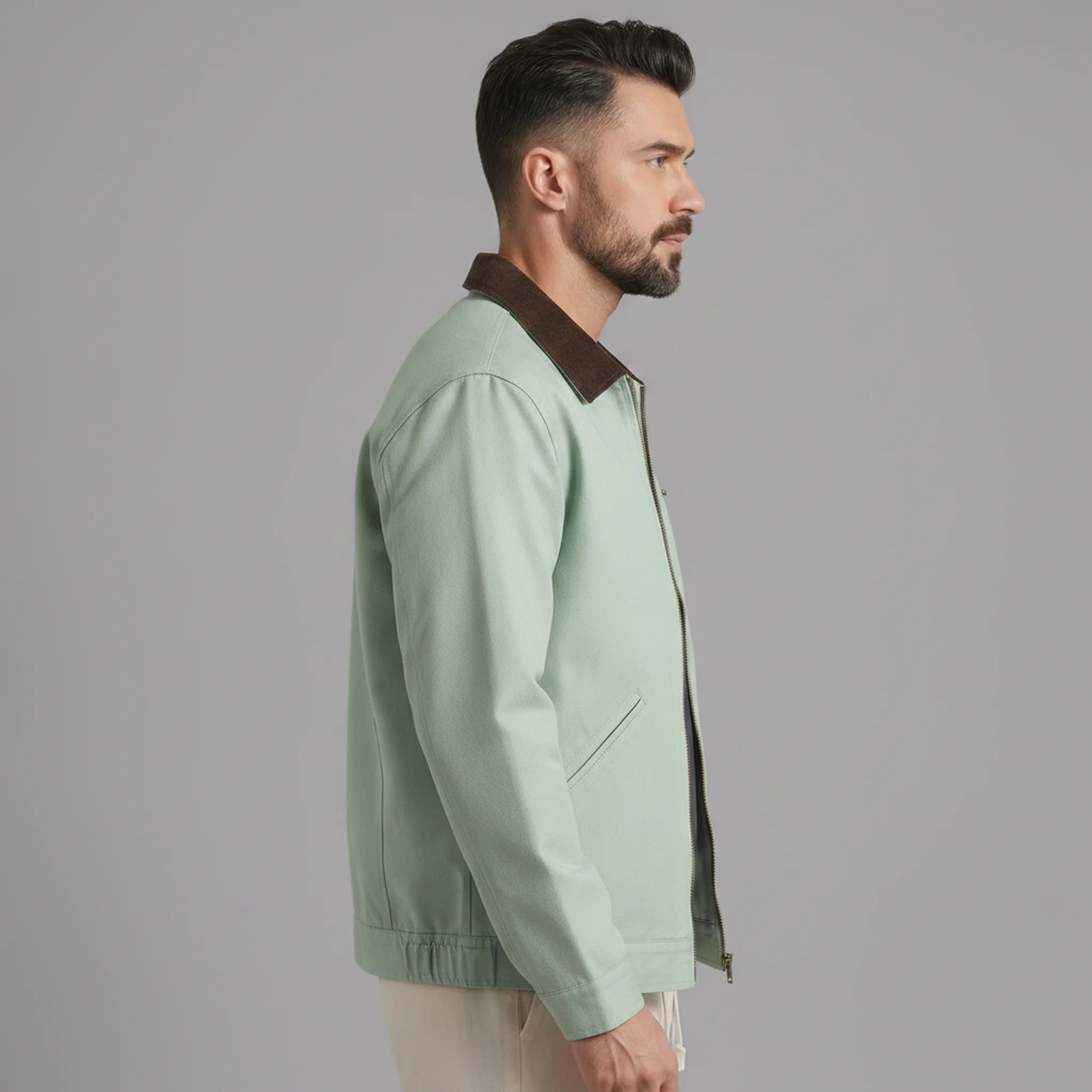 Man wearing MannerCo khaki contrast lapel workwear jacket, side view on plain background