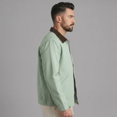 Man wearing MannerCo khaki contrast lapel workwear jacket, side view on plain background