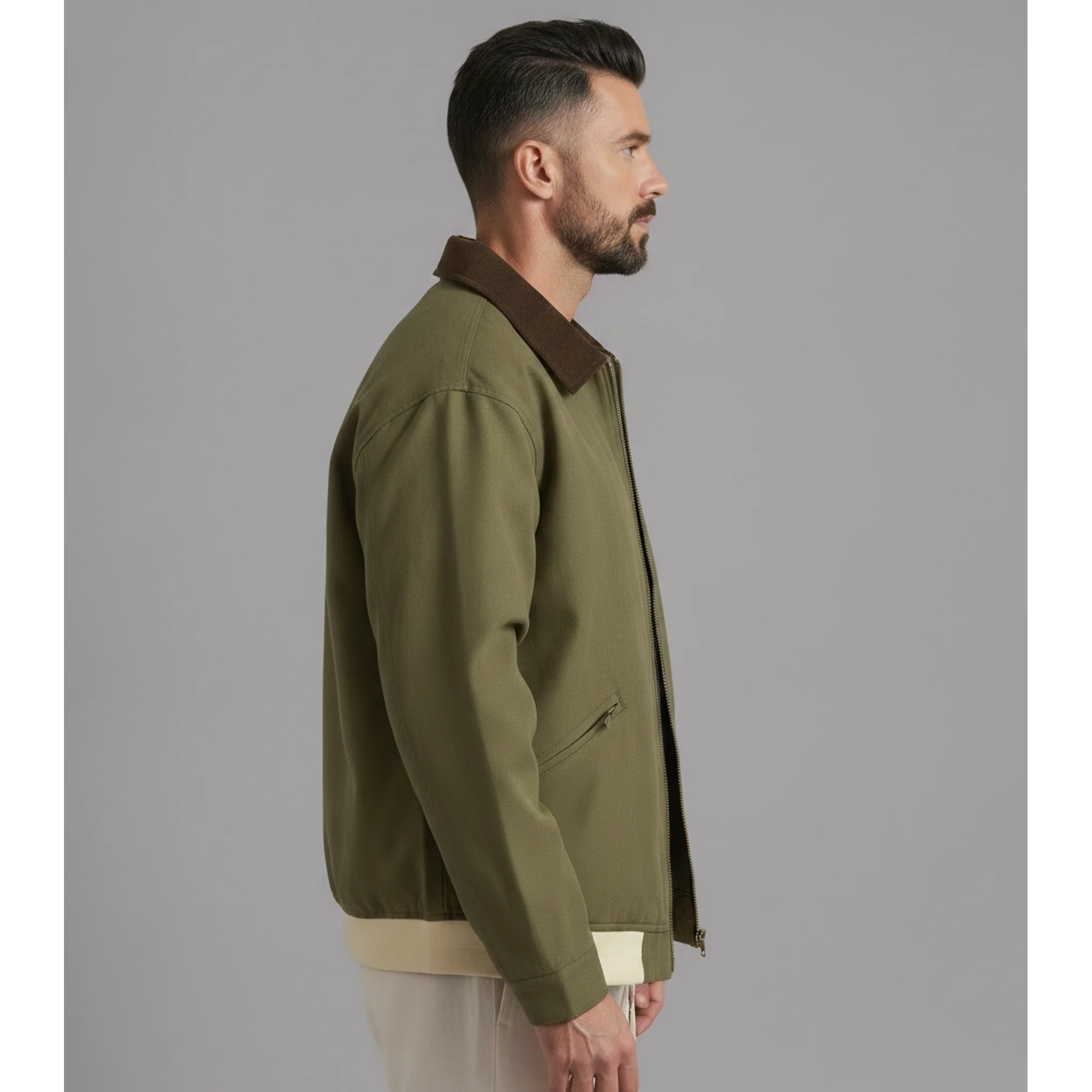 Man wearing MannerCo olive green contrast lapel workwear jacket, side view on plain background