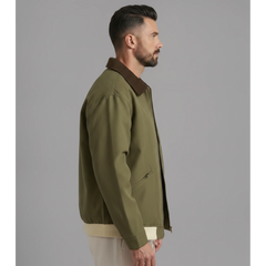 Man wearing MannerCo olive green contrast lapel workwear jacket, side view on plain background