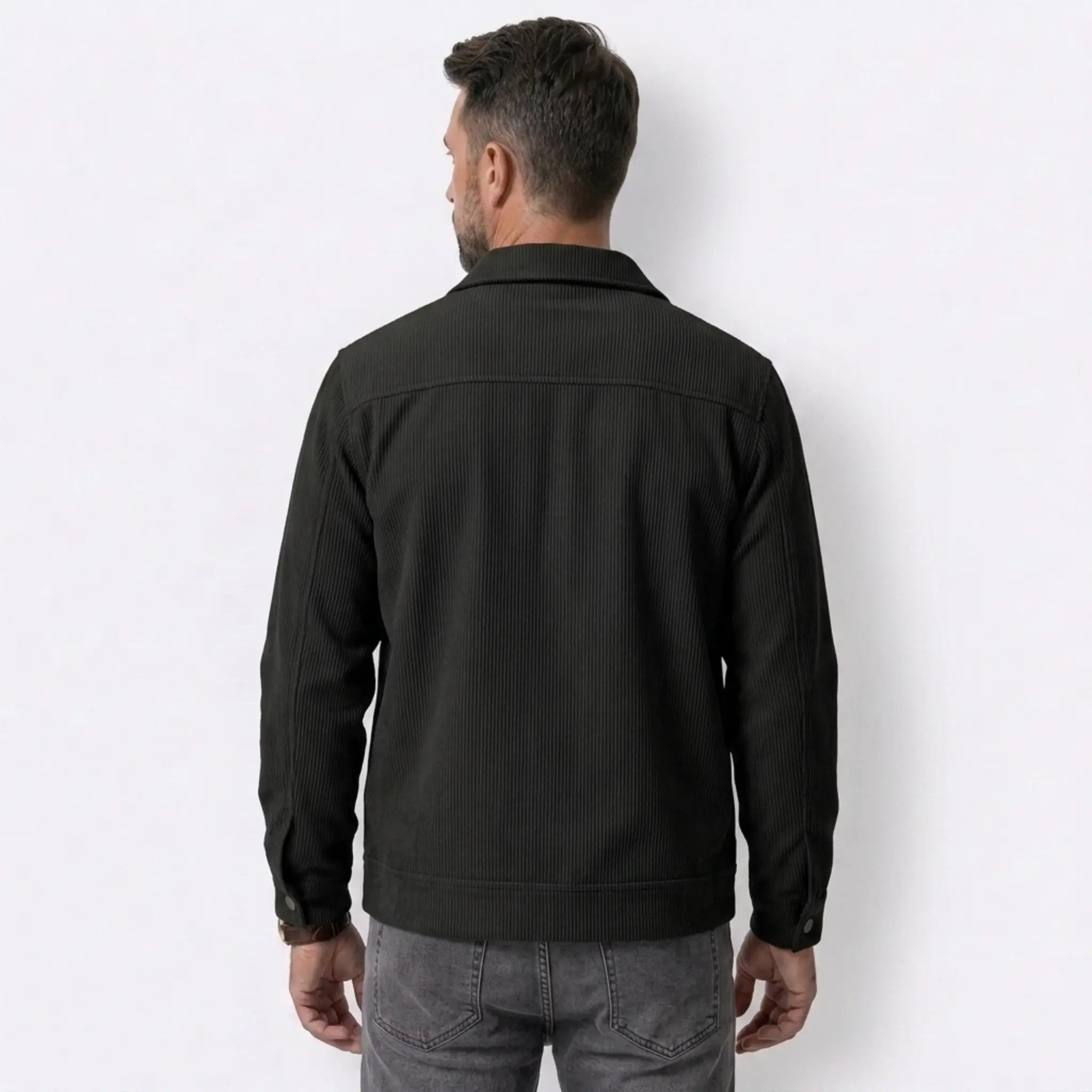 Man wearing MannerCo black corduroy single-breasted lapel jacket in outdoor lifestyle setting