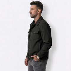 Man wearing MannerCo black corduroy lapel jacket, side view on plain background