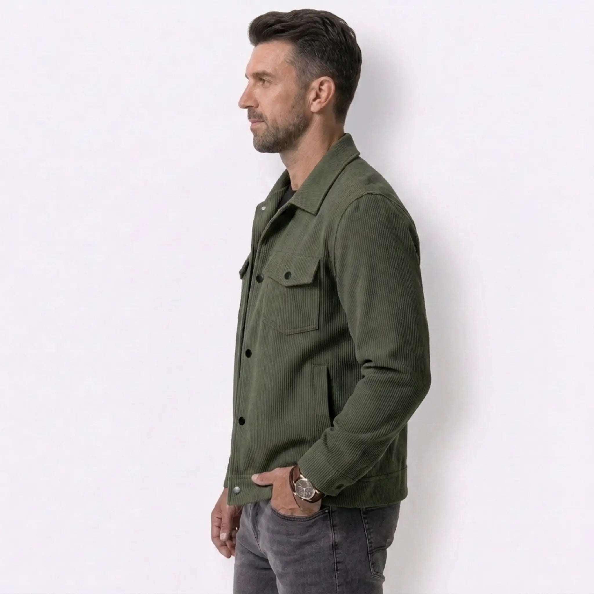 Man wearing MannerCo dark brown corduroy single-breasted lapel jacket, side view on plain background
